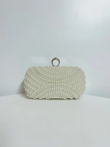 Macro shot of elegant white pearls and crystal-encrusted silver ring buckle on party bag