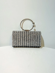 Detailed macro view of rectangular silver evening bag with vertical rhinestone stripes