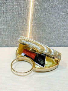 Détail de la pochette de soirée dorée avec perles, strass et doublure en satin jaune