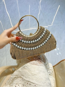 Gros plan détaillé du sac de soirée doré avec strass scintillants et perles blanches