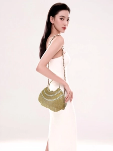 Vue détaillée d'un sac de soirée de luxe avec perles et strass sur une robe blanche