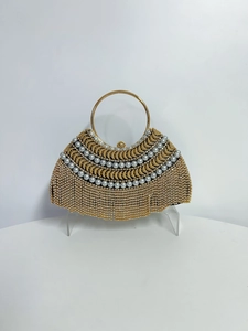 Détail de pochette de soirée luxueuse avec perles blanches et franges métalliques