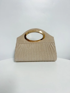 Close-up of champagne gold pleated evening clutch with elegant metallic oval handle