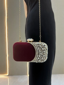 Dettaglio pochette da sera in velluto rosso con strass luminosi e catena dorata