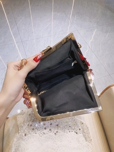 Red sequin evening clutch bag with gold chain strap and floral detail