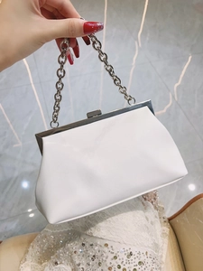 Detail of white leather evening clutch featuring silver ring chain and vintage metal clasp