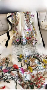Close-up of premium silk scarf featuring vibrant wildflower patterns and exquisite black edging