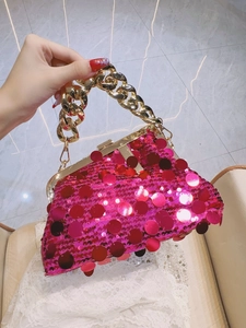 Detailed shot of rose red sequin handbag with gold metal frame and thick chain handle