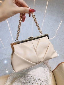 Detail of elegant gathered pleats and chunky gold chain handle on evening clutch