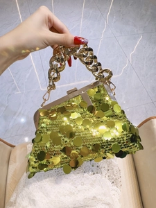 Close-up of bright green sequins evening bag with chunky gold metal chain handle