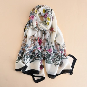 Close-up of floral print silk scarf with black borders and smooth satin texture