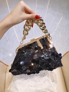 Detail of black sequined evening bag with chunky gold chain handle and vintage clasp