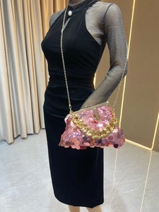Pink sequin evening clutch bag with gold chain strap shown on a mannequin with dress