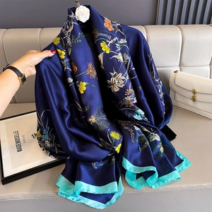 Floral print silk scarf in navy blue with yellow flowers and white camellia brooch
