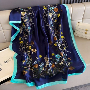 Detail of floral printed silk scarf with blue satin finish and mint green contrast borders