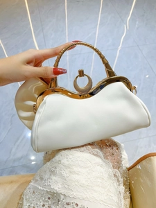 Dettaglio pochette da sera bianca con manico dorato a bambù e chiusura in metallo