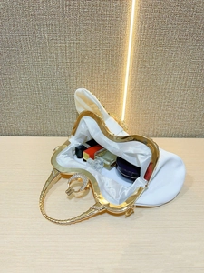 Dettaglio interno della borsa da sera plissettata bianca con chiusura dorata e strass