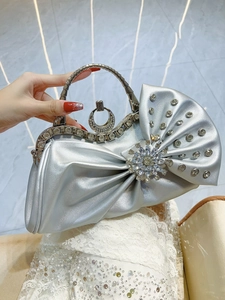Dettaglio borsa da sera argento con girasole di cristallo e fiocco di strass lucido