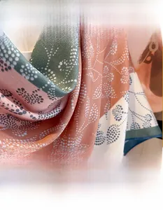 Detailed close-up of the fine textile weave and green leaf print on this silk-feel scarf
