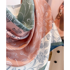 Floral print luxury silk scarf in peach pink and olive green with twill weave texture