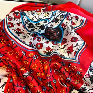 Detailed close-up of vintage floral silk shawl with vibrant red and white botanical patterns