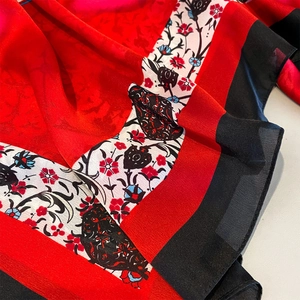 Close-up of red and black floral print on a lightweight beach shawl scarf detail