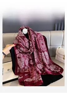 Detail of burgundy pashmina shawl with white paisley prints and silky texture