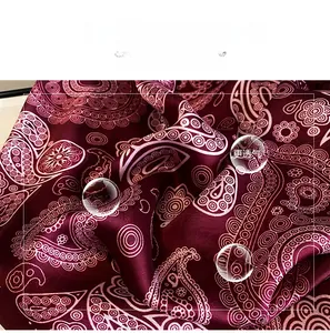 Close-up of burgundy paisley print scarf showing silky texture and elegant fabric folds