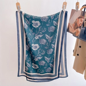 Green vintage poppy floral silk scarf displayed hanging with elegant fashion accessories