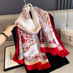 Detail of floral print silk shawl with red borders and smooth pearlescent finish