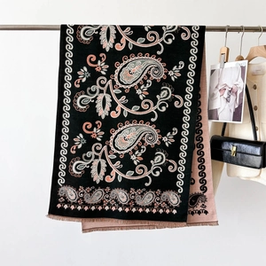 Gros plan d'un châle cachemire réversible à motifs paisley avec des détails de franges