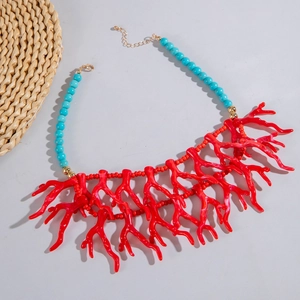 Vue détaillée des pendentifs corail rouge et perles turquoise sur ce collier de style bohème