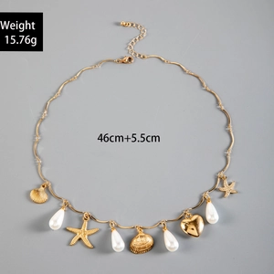 Detail of seashell and starfish charms on a gold chain necklace with size dimensions