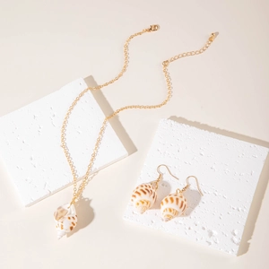 Macro detail of natural seashell necklace and earring set with golden chains and textured shells