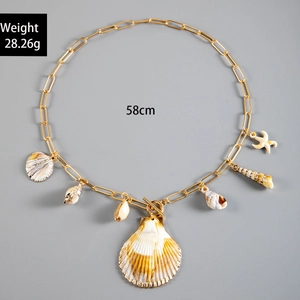 Detail of bohemian shell and starfish charms on a gold T-bar necklace with 58cm length