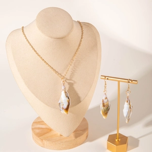 Detailed close-up of natural shell pendant necklace and matching earrings on display