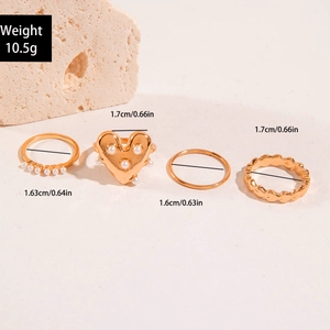 Detail shot of four-piece gold ring set with heart and pearls including size measurements