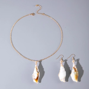 Detailed macro view of natural seashell pendant and matching gold chain earrings set
