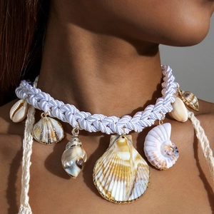 Detail of bohemian woven choker with natural shells and golden metal rimmed pendants