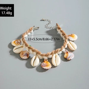 Detail of bohemian shell necklace with natural scallops, starfish, and pearls on woven rope