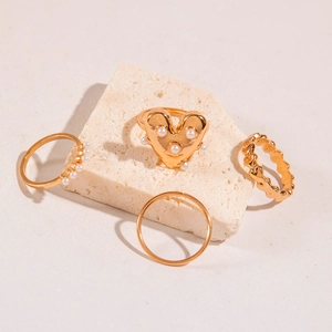 Golden multi-layer ring set with pearls and heart accent on stone display