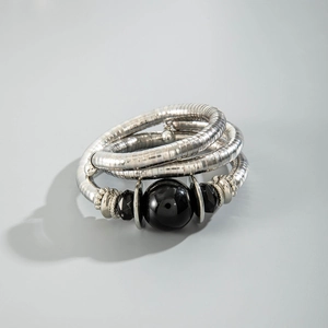 Detail of silver snake chain bracelet featuring multi-layer design and black beads