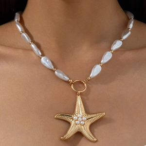Close-up of golden starfish pendant with baroque pearls and sunburst texture on necklace