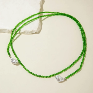 Detail of green crystal beads and white baroque pearls on a minimalist long Y-necklace