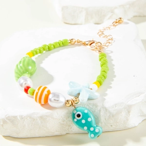 Detailed shot of green beads bracelet with starfish, shell, and fish charms for beachwear