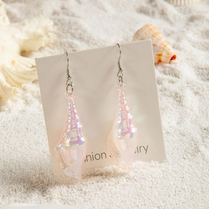 Iridescent pink acrylic conch shell drop earrings on jewelry card with sea sand background