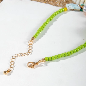 Close-up of handmade green seed bead necklace with gold clasp and starfish detail