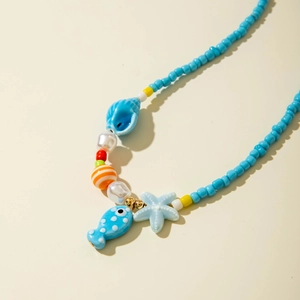 Detail showing blue seed beads with starfish, shell, and fish charms on beach necklace