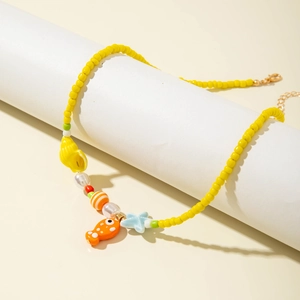 Close-up of yellow beaded ocean necklace with shell, starfish, and fish charms