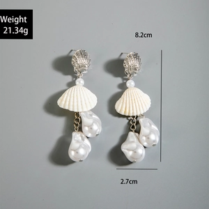 Detail view of beach style seashell earrings with baroque pearls and silver shell studs